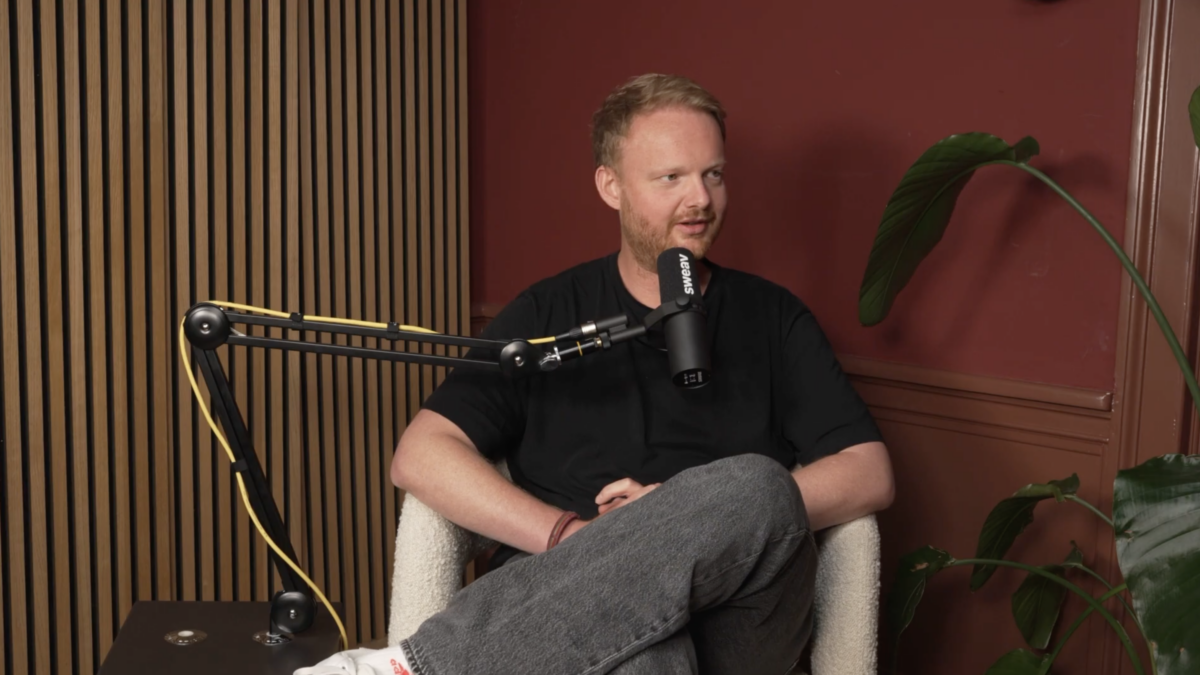 Joeri sitting in a chair talking into a microphone